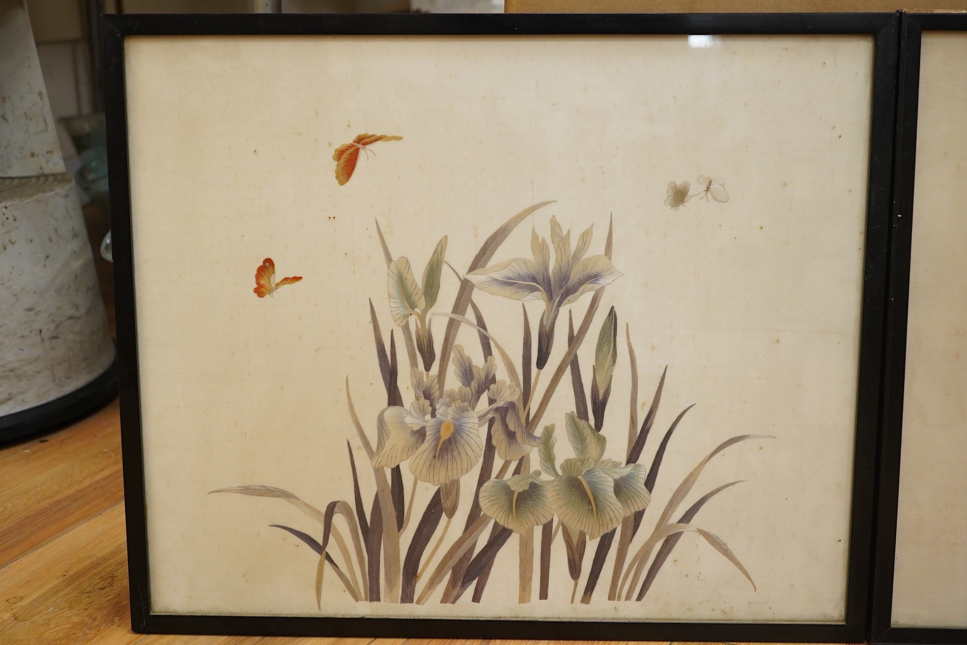 Two early 20th century Japanese cream silk polychromes embroidered panels of flowers birds and butterflies, largest 45cm wide x 37cm high. Condition - there are marks on the cream silk, which may be able to be profession